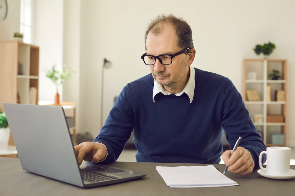 Online language school owner looking at software checklist on computer